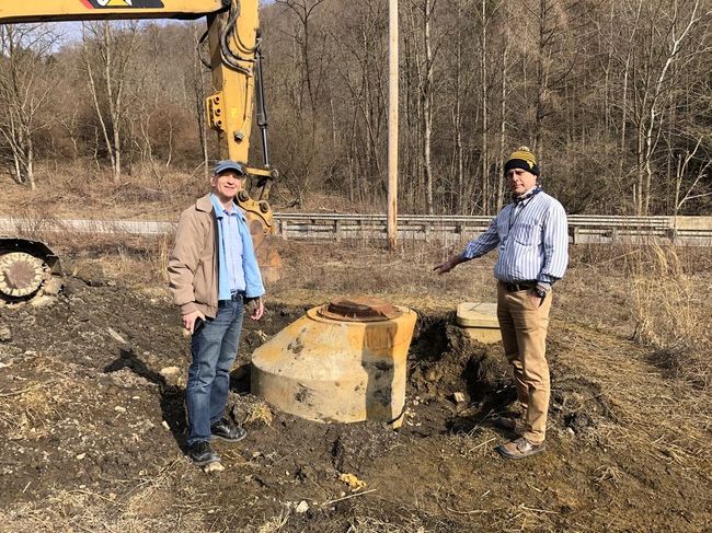 WVU researchers Jeff Skousen and Paul Ziemkiewicz visit the site where an uncontrolled discharge of acidic water flowed through a broken manhole near an acid mine drainage treatment site in Albright, Preston County. Provided Photo
