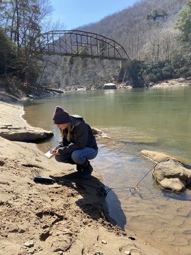 Sarah Cayton, project manager with the West Virginia Water Research Institute, samples the Cheat River on March 8, 2021. (Joe Kingsbury Photo)