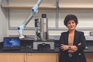 Dr. Shika Sharma pictured in a WVU laboratory with a geothermal reactor 